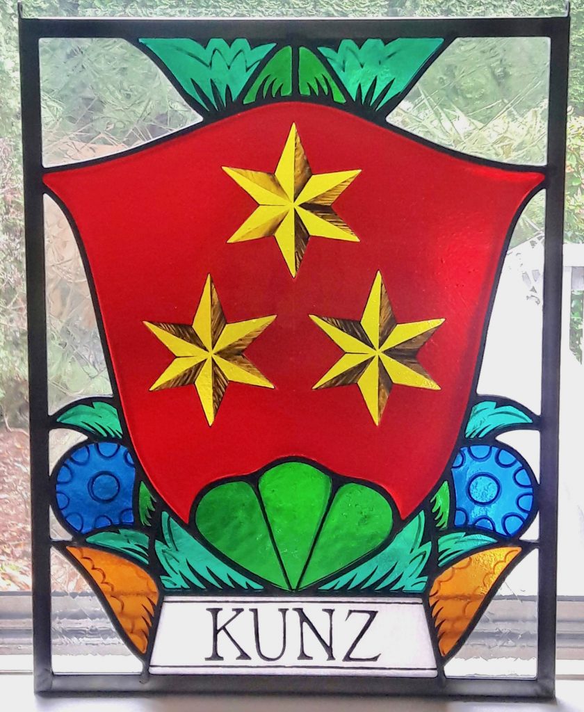 Caron Art Glass stained glass panels family crest Kunz Family Crest fused glass hand painted details red yellow green blue teal amber white rectangle zinc frame