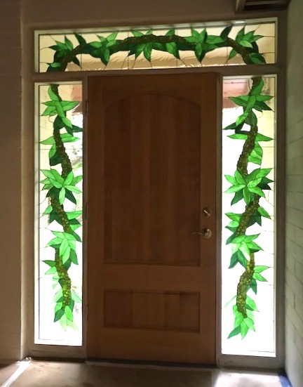 Caron Art Glass architectural art glass entryway transom sidelights stained glass Mokihana and Maile Lei tropical leaves berries garland lei green clear textured