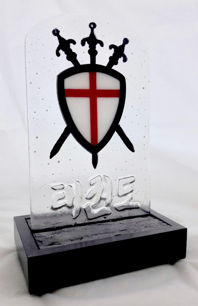 Caron Art Glass fused glass sculpture Taekwondo group logo kiln carved glass red white black arched rectangle shield swords slate wood base