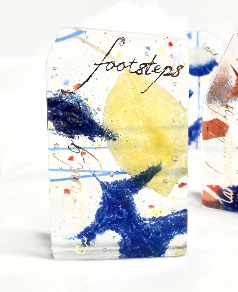 fused glass cairn with fossil vitra yellow blue enameled leaves gold lettering direct and guide footsteps Michelle Caron Caron Art Glass